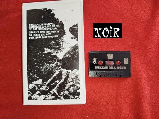 Kkuba102-Ruecken_Zur_Wand-TAPE-DE-2025-NOiR